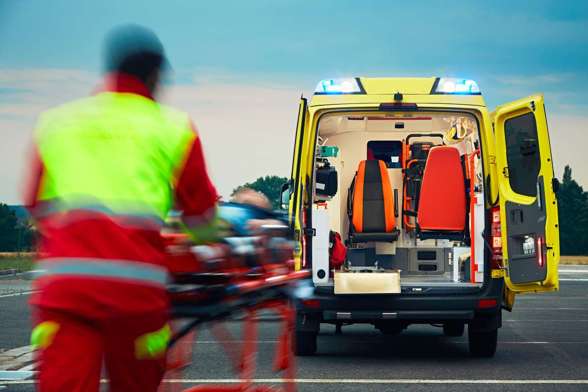 Sanitärer bringt einen Patienten zum Krankenwagen