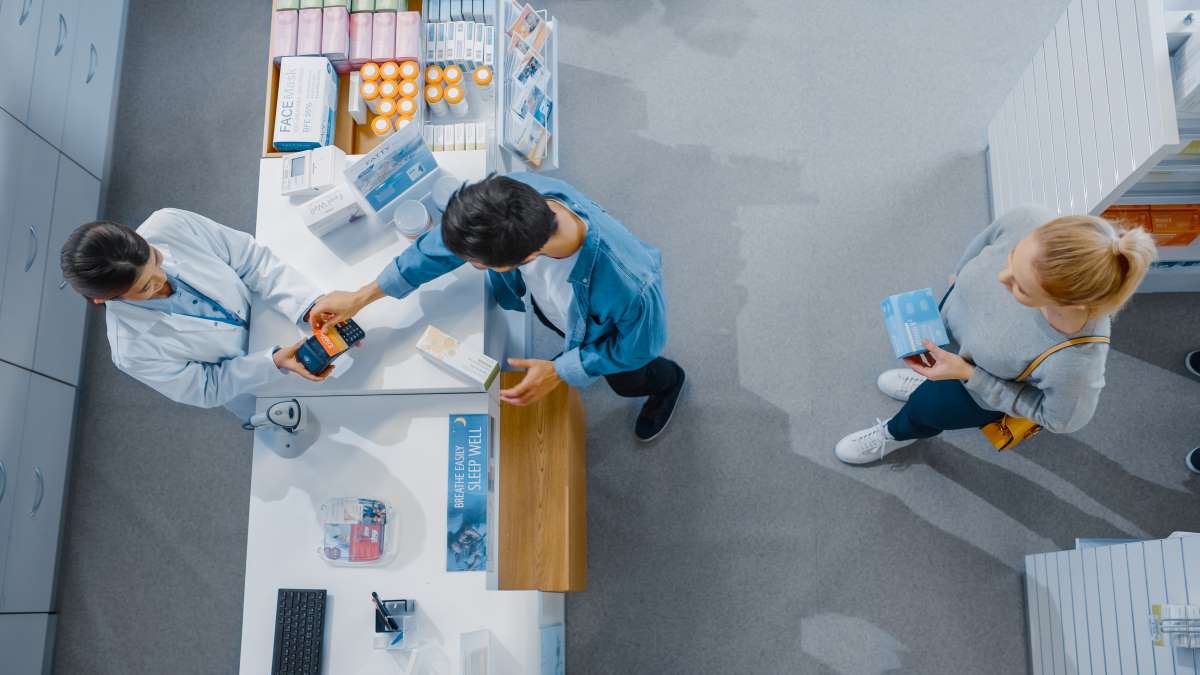 Ein Gespräch und Zahlung an der Kasse einer Apotheke